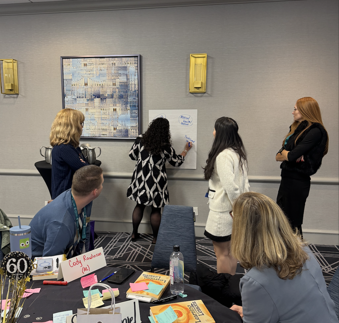 Amanda facilitating a group activity with educators at a wall
